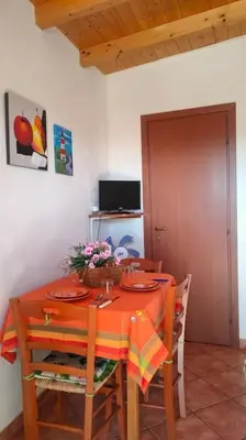 a dining room table and chairs with a orange table cloth at Casetta verde 1 Climatizzata in Castellammare del Golfo
