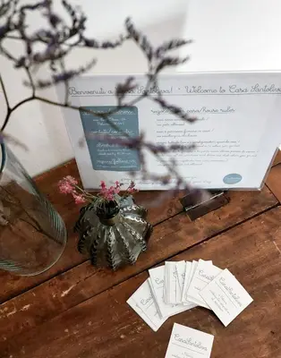 a table with a card and a vase with flowers at Casa Santoliva in centro a Palermo in Palermo