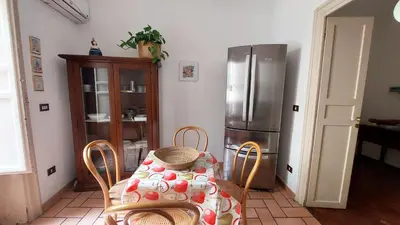 a kitchen with a table and a refrigerator at Casa Santoliva in centro a Palermo in Palermo