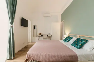 a bedroom with a large bed with blue pillows at Sofia's Central Apartment Palermo in Palermo