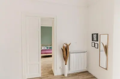 a room with a white door and a vase with feathers at Sofia's Central Apartment Palermo in Palermo