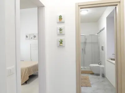 a white bathroom with a toilet and a sink at Casa Lumìa in Palermo