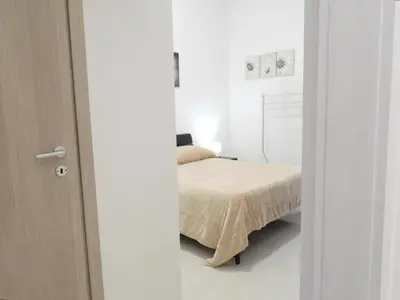 a bedroom with a bed in a white room at Casa Lumìa in Palermo