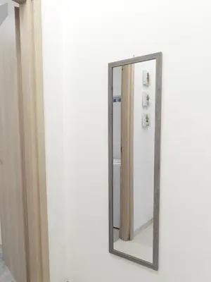 a mirror hanging on a white wall in a room at Casa Lumìa in Palermo