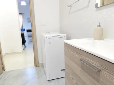 a bathroom with a white refrigerator and a sink at Casa Lumìa in Palermo