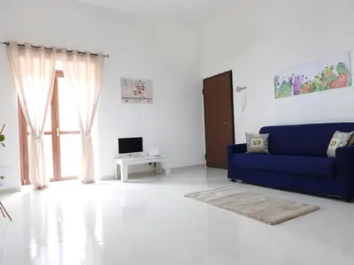 a living room with a blue couch and a tv at Casa Lumìa in Palermo