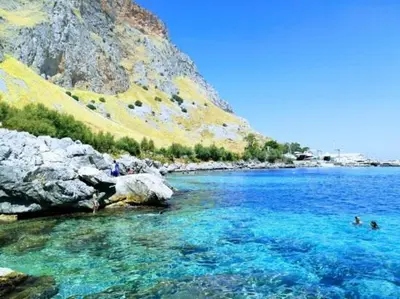 a body of water with people swimming in it at Sikanart Home in Palermo