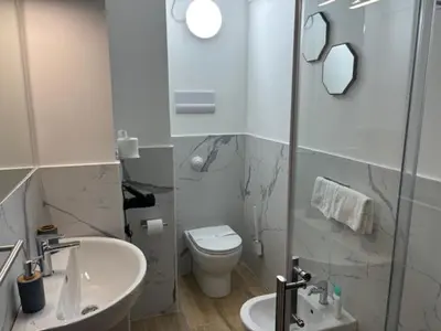 a white bathroom with a sink and a toilet at Sikanart Home in Palermo