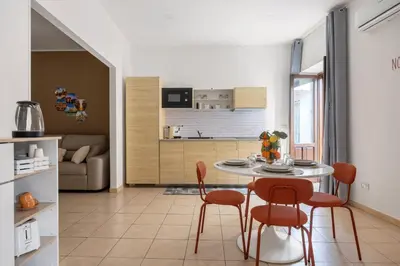 a kitchen and living room with a table and chairs at Palermo of living appartamento Centro Storico in Palermo