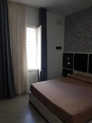 a bedroom with a bed and a window at B&B Il Sole in Castelluzzo