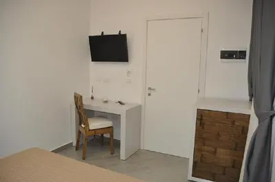 a room with a desk with a chair and a television at B&B Il Sole in Castelluzzo