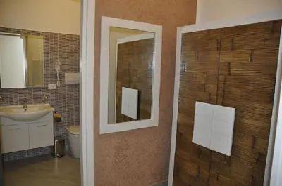 a bathroom with a sink and a toilet and a mirror at B&B Il Sole in Castelluzzo