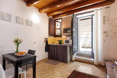 a living room with a table and a kitchen at GuestHost - GuestHost - Giusino Experience in Palermo's Heart in Palermo