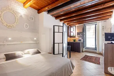 a bedroom with a large bed and a bathroom at GuestHost - GuestHost - Giusino Experience in Palermo's Heart in Palermo