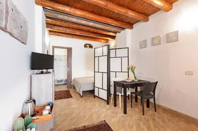 a living room with a table and a bedroom at GuestHost - GuestHost - Giusino Experience in Palermo's Heart in Palermo