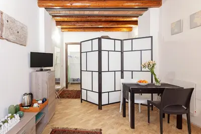 a dining room with a black table and a tv at GuestHost - GuestHost - Giusino Experience in Palermo's Heart in Palermo
