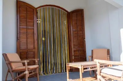 a room with a door and a table and chairs at La perla sulla spiaggia in Alcamo Marina