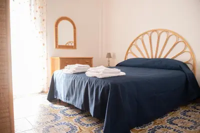 a bedroom with a blue bed with a blue blanket at La perla sulla spiaggia in Alcamo Marina