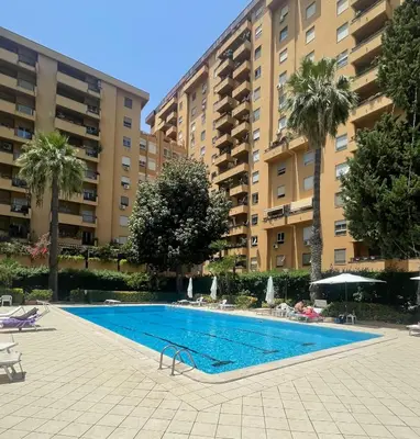 a swimming pool in front of two large buildings at Claudio House Palermo in Palermo