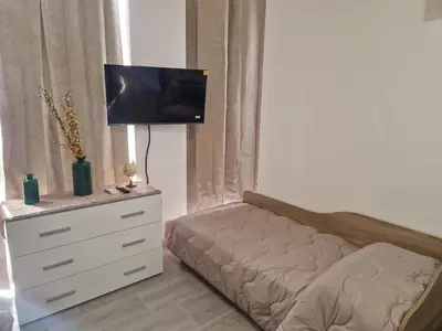 a bedroom with a bed and a dresser with a tv on it at Claudio House Palermo in Palermo
