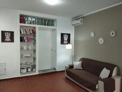 a living room with a couch and a book shelf at Appartamento centro storico.(Nina's house Venezia) in Palermo