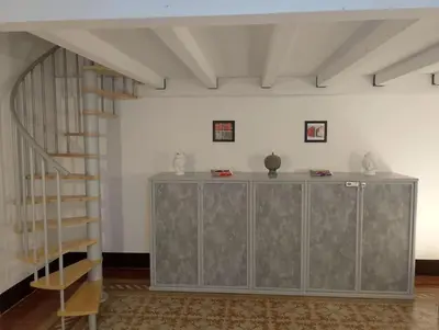 a living room with a staircase and a shelf at Appartamento centro storico(Nina's house stazione) in Palermo