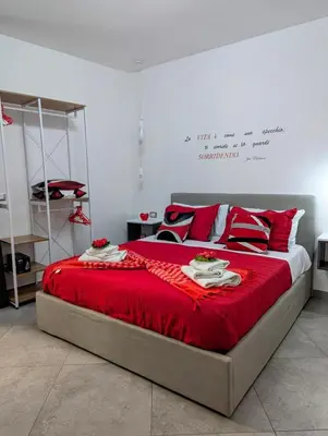 a bedroom with a large bed with a red blanket at I colori della Sicilia in Cinisi