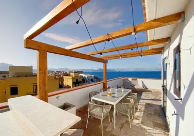 a patio with a table and chairs on a balcony at Solemar Sicilia - Casa Tosca in Ficarazzi