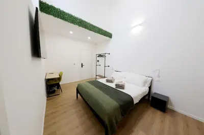 a bedroom with a bed and a television in it at Argenteria5 Holiday Rooms in Palermo