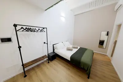 a bedroom with a bed in a white room at Argenteria5 Holiday Rooms in Palermo
