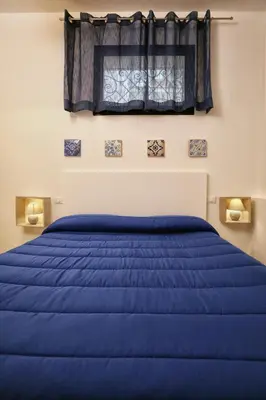 a blue bed in a bedroom with a window at Casa Le Nereidi in Castellammare del Golfo