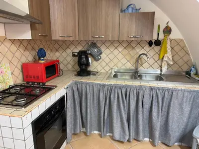 a kitchen with a microwave on a stove and a sink at L' Arco Antico in Palermo