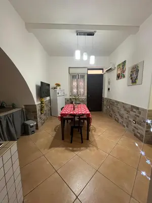 a dining room with a table and a kitchen at L' Arco Antico in Palermo