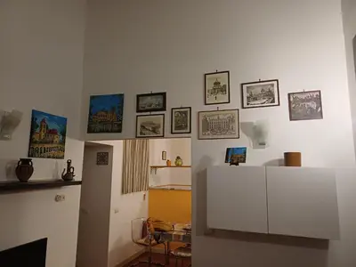 a room with a white wall with pictures on it at Appartamento Alessandro al porto in Palermo