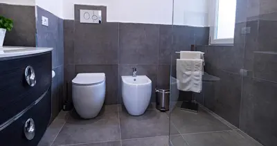 a bathroom with a toilet and a sink at NIKA NIKA Holiday House in Carini