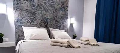 a bedroom with a large bed with blankets and pillows at NIKA NIKA Holiday House in Carini