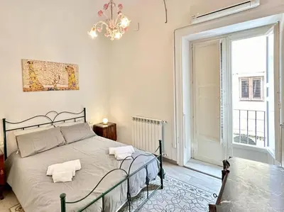 a bedroom with a bed and a large window at Residenza Cattedrale in Palermo