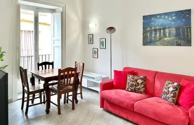 a living room with a red couch and a table at Residenza Cattedrale in Palermo