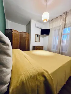 a bedroom with a bed with a yellow blanket at Reef Mondello Apartment in Palermo