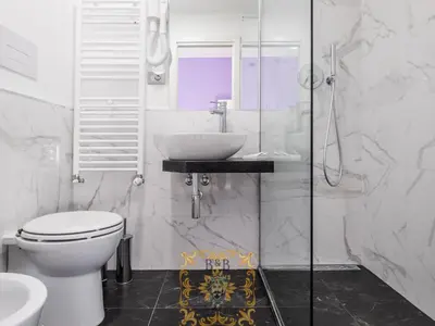 a white bathroom with a toilet and a sink at Testa del Moro - Nel Cuore di Palermo in Palermo