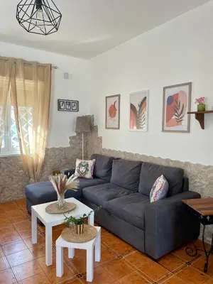 a living room with a blue couch and a table at La Villetta di Sofia in Carini