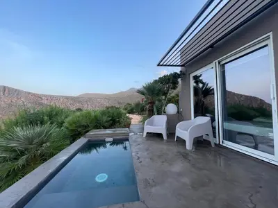 a backyard with a swimming pool and chairs and a house at QUIETE e MARE in San Vito lo Capo