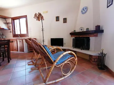 a rocking chair in a living room with a fireplace at Villa Francesca in Castelluzzo