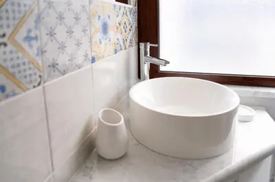 a bathroom with a white sink and a window at Vista Mare Rooms in Isola delle Femmine