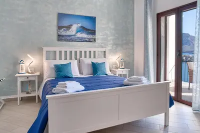 a bedroom with a large bed with blue sheets and pillows at Vista Mare Rooms in Isola delle Femmine