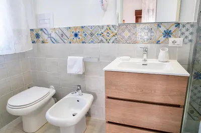 a bathroom with a toilet and a sink and a toilet at Vista Mare Rooms in Isola delle Femmine