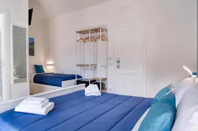 a bedroom with a blue bed with towels on it at Vista Mare Rooms in Isola delle Femmine