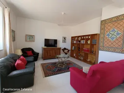 a living room with two couches and a tv at Casa Vacanze Zafarana in Santa Flavia