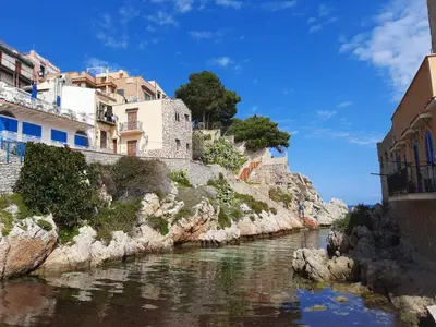 a river with buildings on the side of a hill at Casa Vacanze Zafarana in Santa Flavia