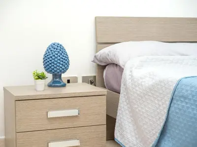 a bedroom with a bed and a night stand with a blue cactus at Isola delle Femmine - Casetta del Pescatore in Isola delle Femmine